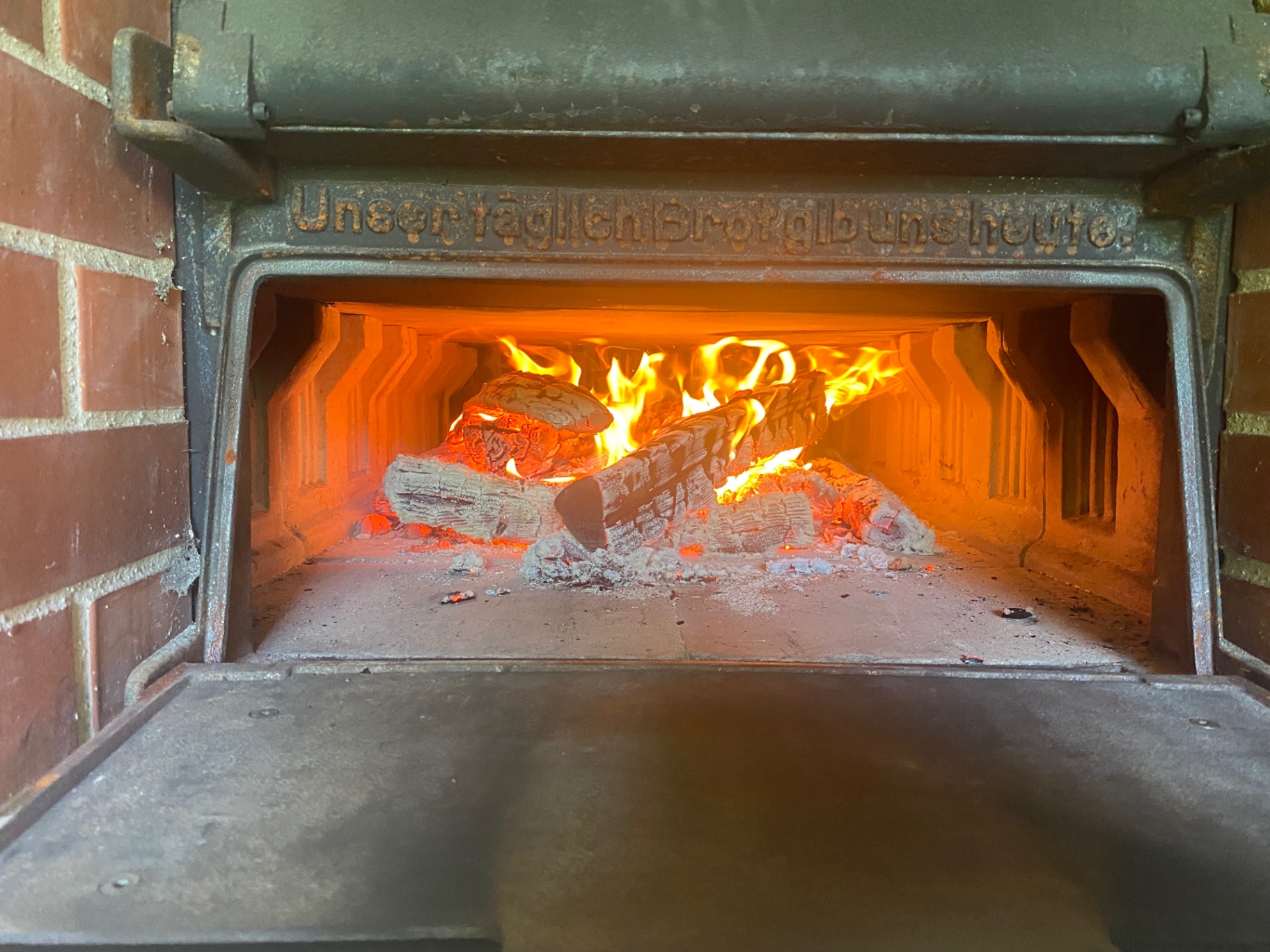 Brennendes Holz im Holzbackofen – ‚Unser täglich Brot gib uns heute‘