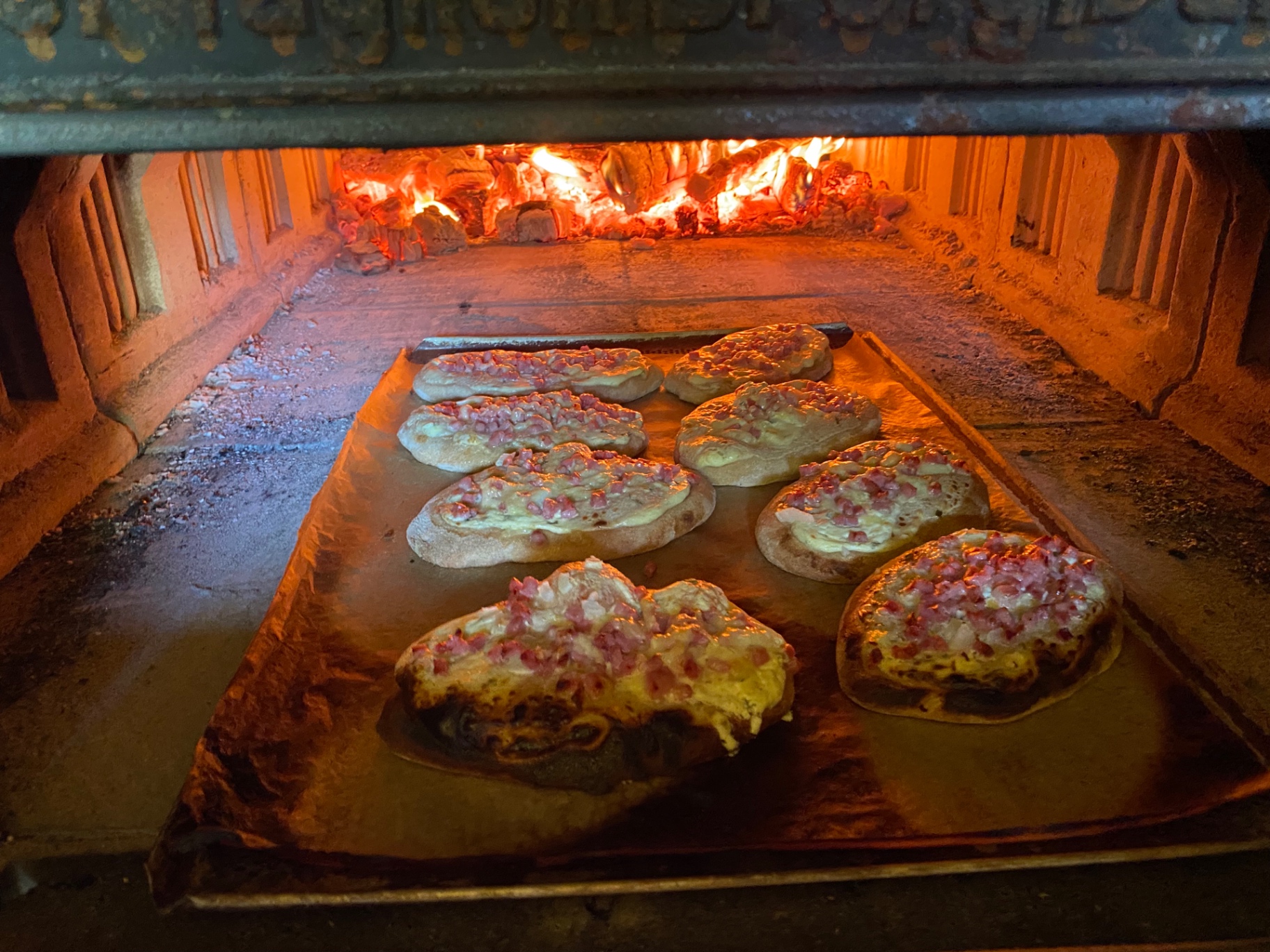 Rahmfleckerl backen im Holzbackofen über glühender Glut