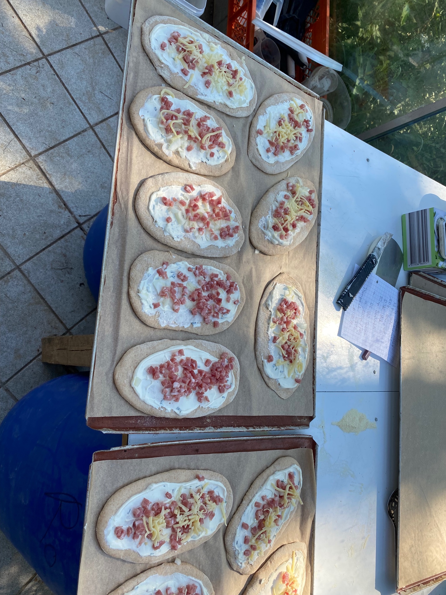 Belegte Rahmfleckerl auf Blechen vor dem Backen